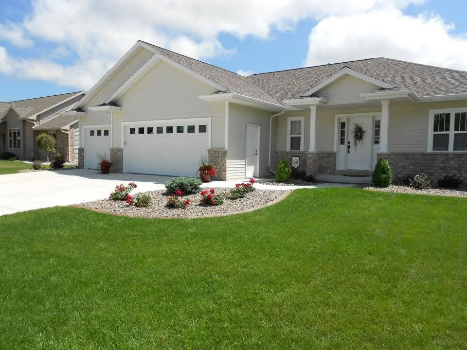 Home with a landscaped lawn and garden beds ready for the colder season